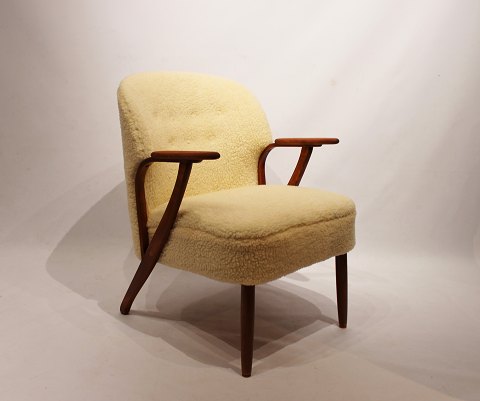 Hvilestol polstret med fåreuld og med arme af mørkt træ af dansk design fra 
1960erne.
5000m2 udstilling.