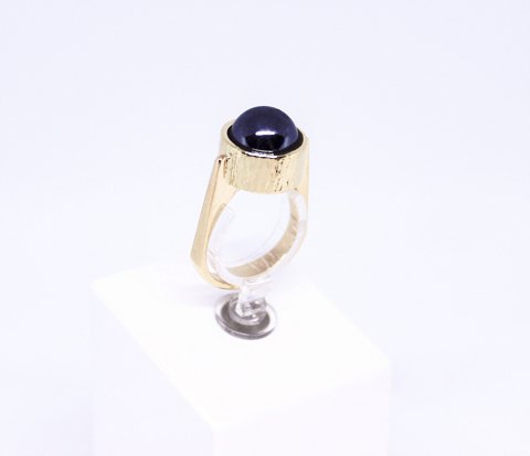 Ring of 14 carat gold decorated with a blood stone and stamped KVA.
5000m2 showroom.