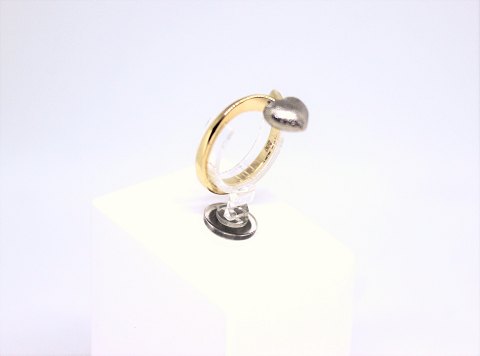 Ring of 14 carat gold decorated with a silver heart and stamped mpg.
5000m2 showroom.