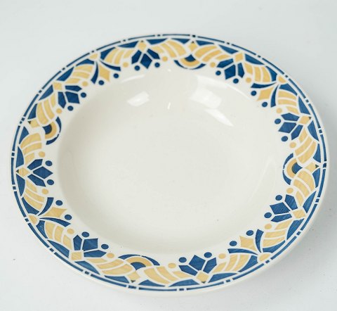 Deep dinner plate decorated with blue and yellow colours from the 1960s. 
5000m2 showroom.