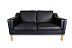 Black leather 2 seater sofa with legs of oak, manufactured by Stouby Furniture 
in the 1960s.
